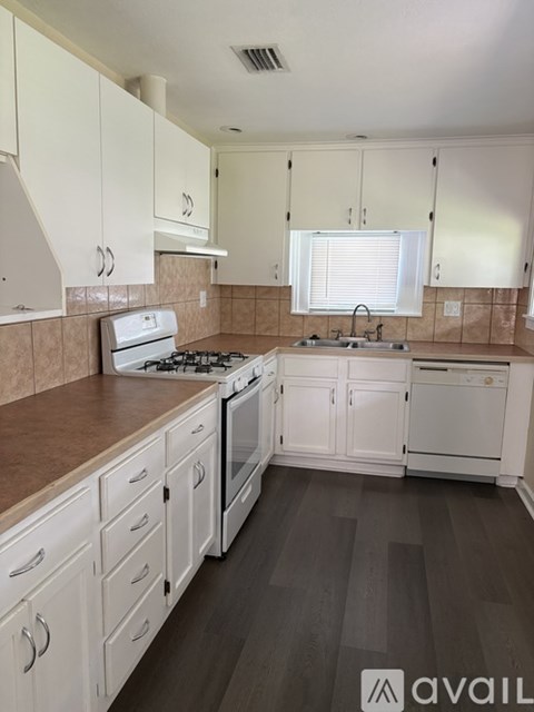 A kitchen with white cabinets and a tiled backsplash.