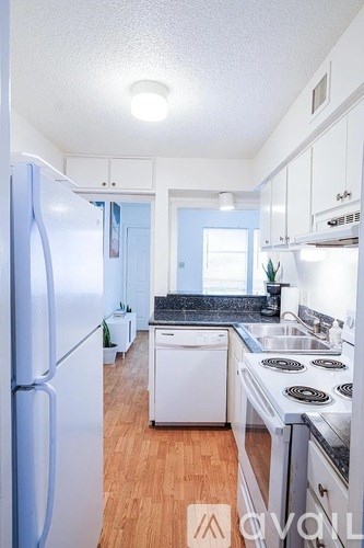 A kitchen with a white fridge and a white dishwasher.