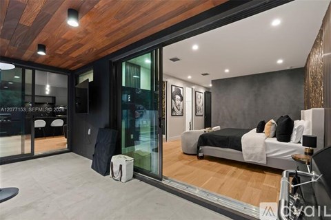 A modern bedroom with a large bed and a wooden ceiling.