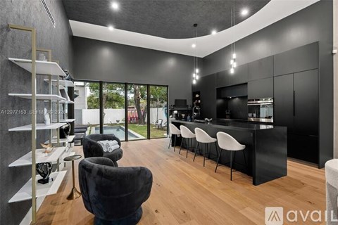 A modern kitchen with black cabinets and white countertops.