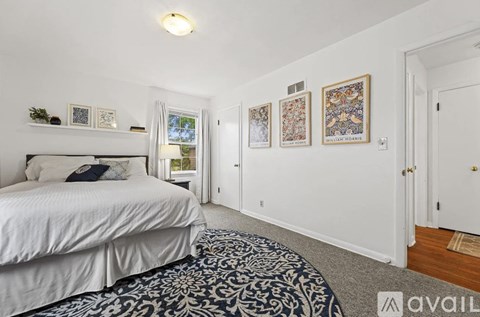 A bedroom with a large bed and pictures on the wall.