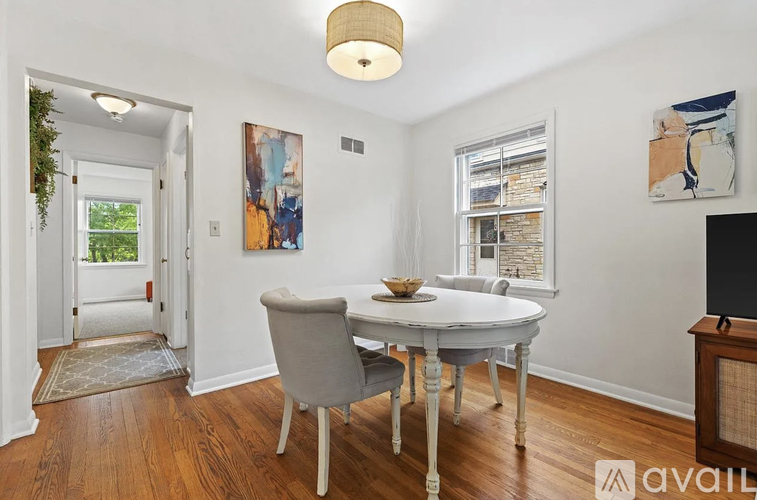 A dining room with a white table and chairs.