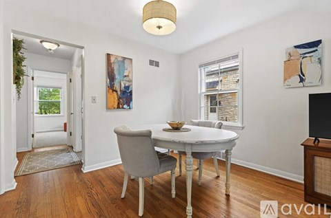 A dining room with a white table and chairs.