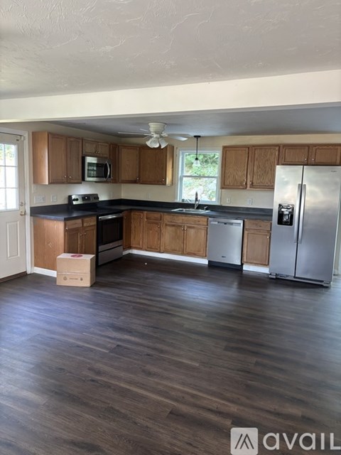 A kitchen with wooden cabinets and a refrigerator.