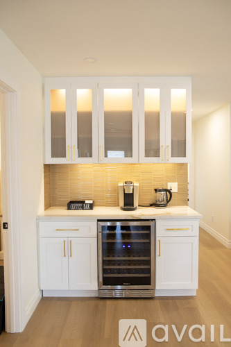 A kitchen with white cabinets and a wine cooler.