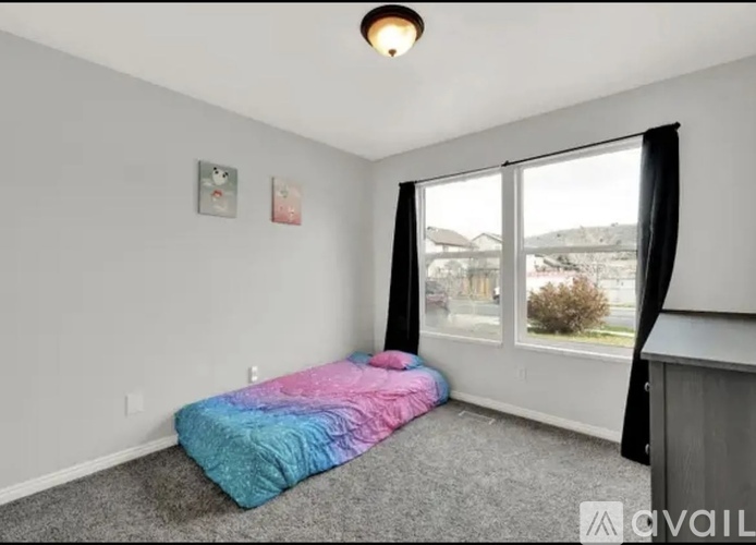 A bedroom with a bed and a window.