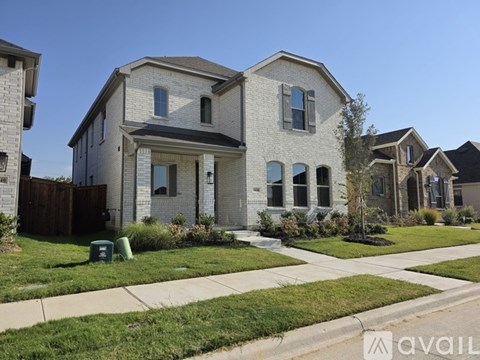 A modern house with a grey brick exterior and a large front yard.
