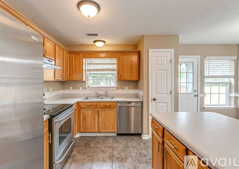 A kitchen with wooden cabinets and a stainless steel refrigerator.