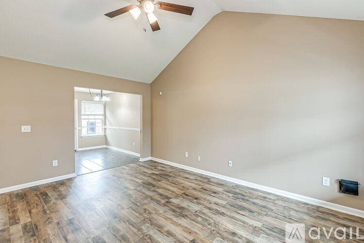 A room with wooden flooring and a ceiling fan.