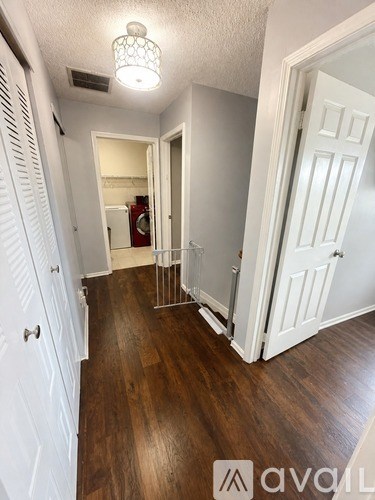 A hallway with a white door and a white cabinet.