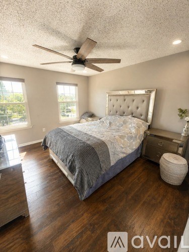 A bedroom with a large bed and a ceiling fan.