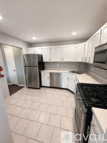 A kitchen with white cabinets and a black stove top.