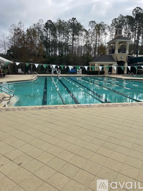 A large swimming pool with a diving board and a small building in the background.