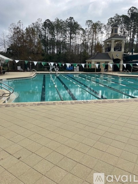 A large swimming pool with a diving board and a small building in the background.