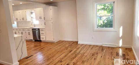 A kitchen with white cabinets and a window.