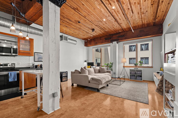 A spacious living room with a kitchen area and a dining table.