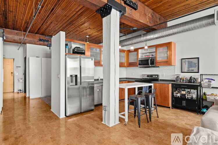 A kitchen with a wooden ceiling and a white fridge.