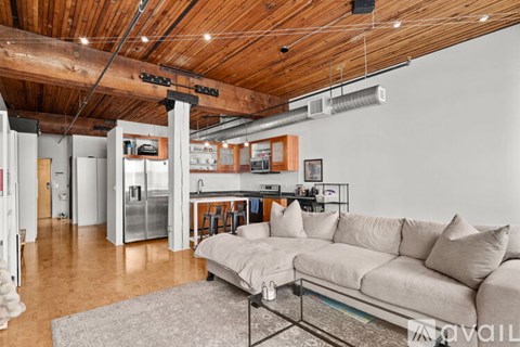A living room with a couch and a kitchen in the background.