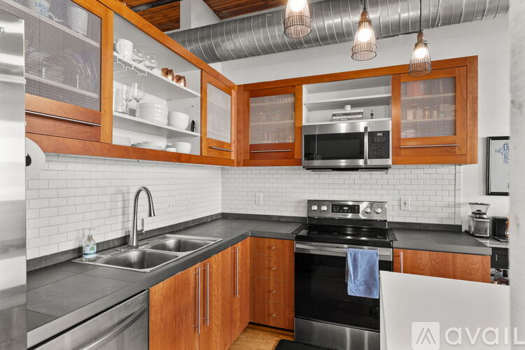 A kitchen with wooden cabinets and a stainless steel sink.