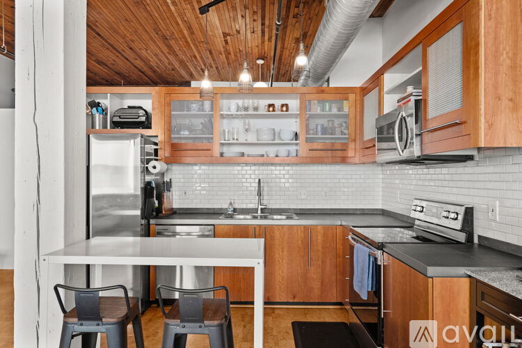 A kitchen with wooden cabinets and a white table.