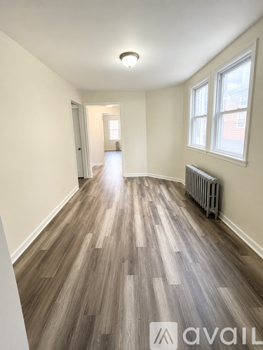 A room with wooden flooring and a window.