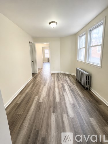 A room with wooden flooring and a window.