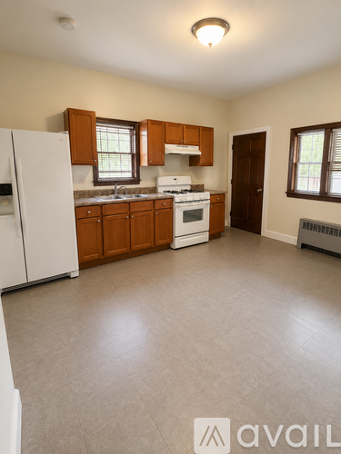 A kitchen with white appliances and wooden cabinets.
