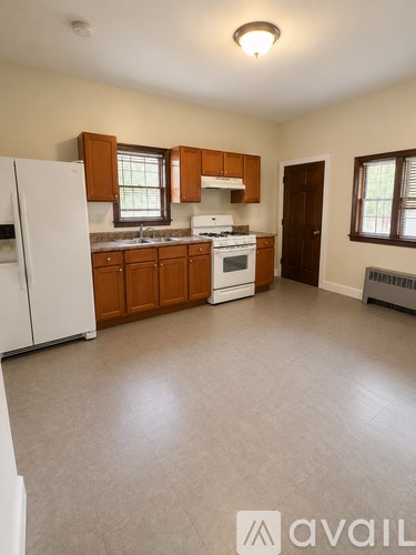 A kitchen with white appliances and wooden cabinets.