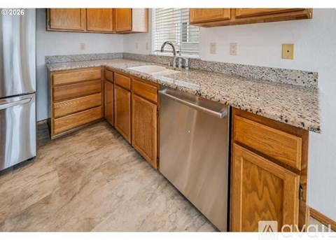 A kitchen with wooden cabinets and a granite countertop.