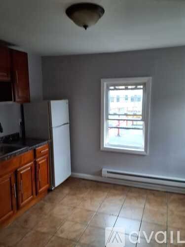 A kitchen with a refrigerator and a window.