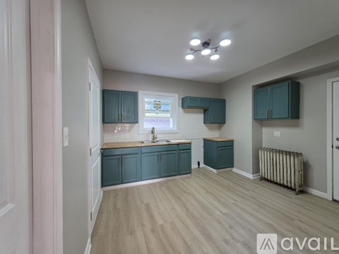 A kitchen with teal cabinets and a white wall.