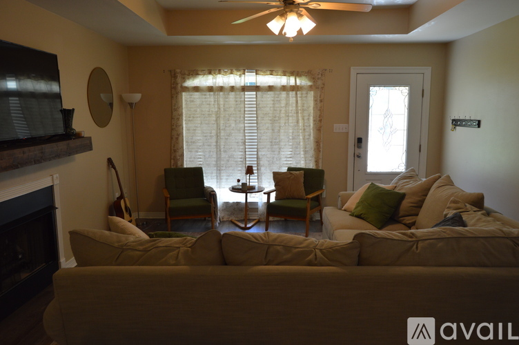 A living room with a couch, chairs, and a fireplace.