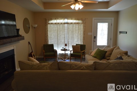 A living room with a couch, chairs, and a fireplace.