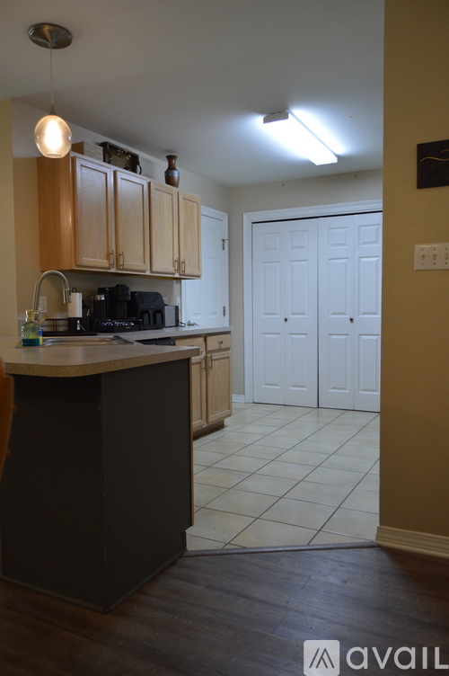 A kitchen with wooden cabinets and a black island.