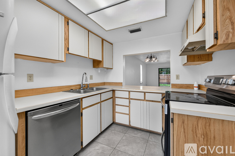 A kitchen with white cabinets and a wooden counter.