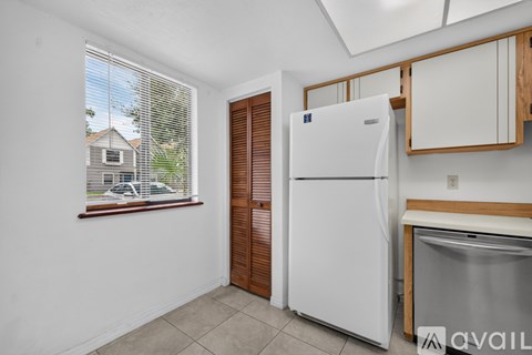 A kitchen with a white fridge and wooden cabinets.