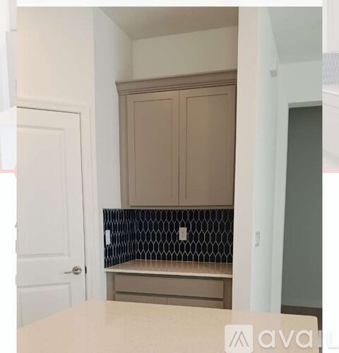 A kitchen with a white counter top and a backsplash with a black and white pattern.