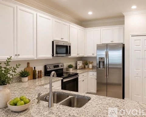 A kitchen with white cabinets and stainless steel appliances.