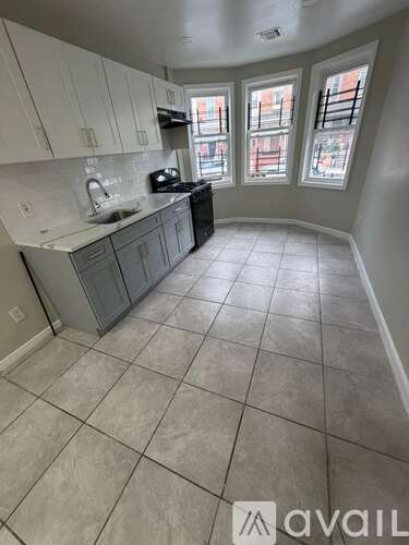 A kitchen with tile flooring and a window.