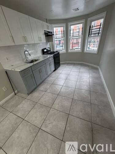 A kitchen with tile flooring and a window.