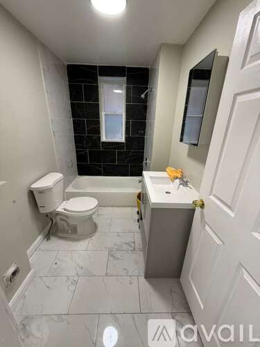 A bathroom with a toilet, sink, and bathtub.