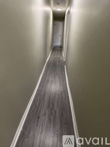 A long hallway with a wooden floor and walls.