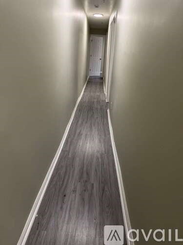 A long hallway with a wooden floor and walls.