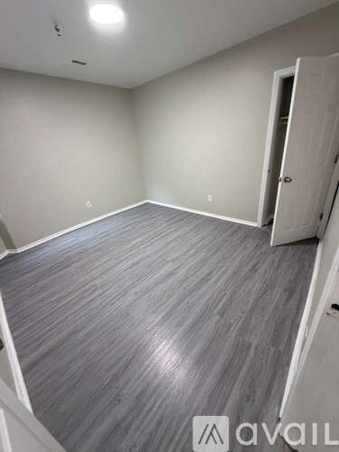 A room with a grey floor and a white door.