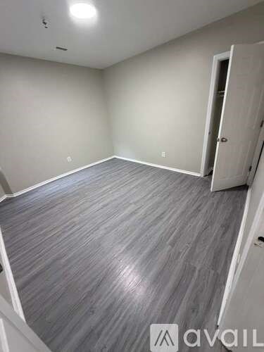 A room with a grey floor and a white door.