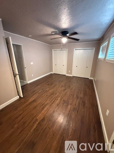 A room with wooden flooring and a ceiling fan.