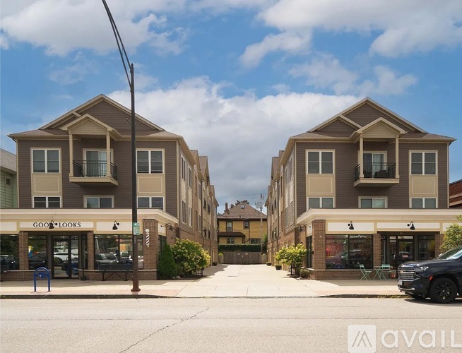 Two identical buildings with the sign "GOOD LOOKS" in front of them.