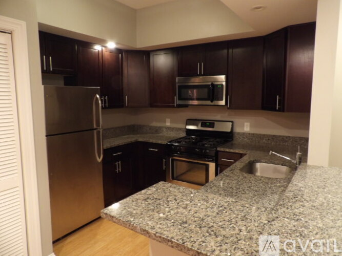 A kitchen with dark brown cabinets and stainless steel appliances.