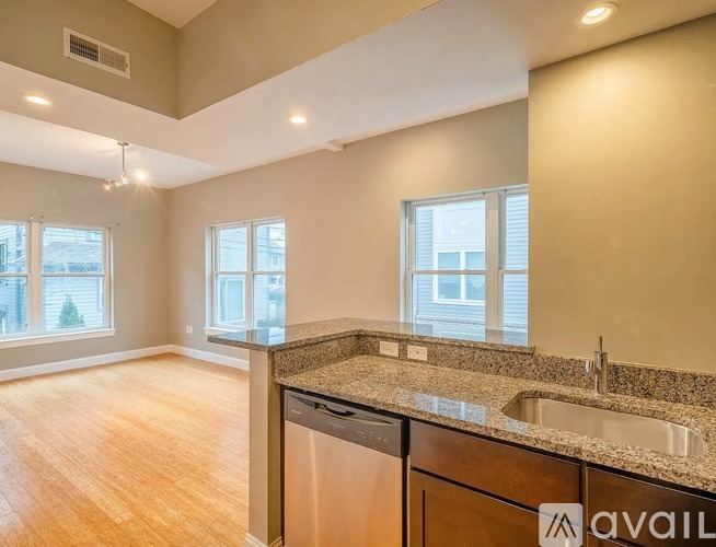 A kitchen with a granite countertop and a dishwasher is available for rent.