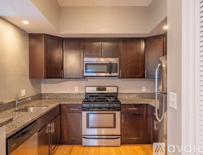 A kitchen with dark wood cabinets and stainless steel appliances.
